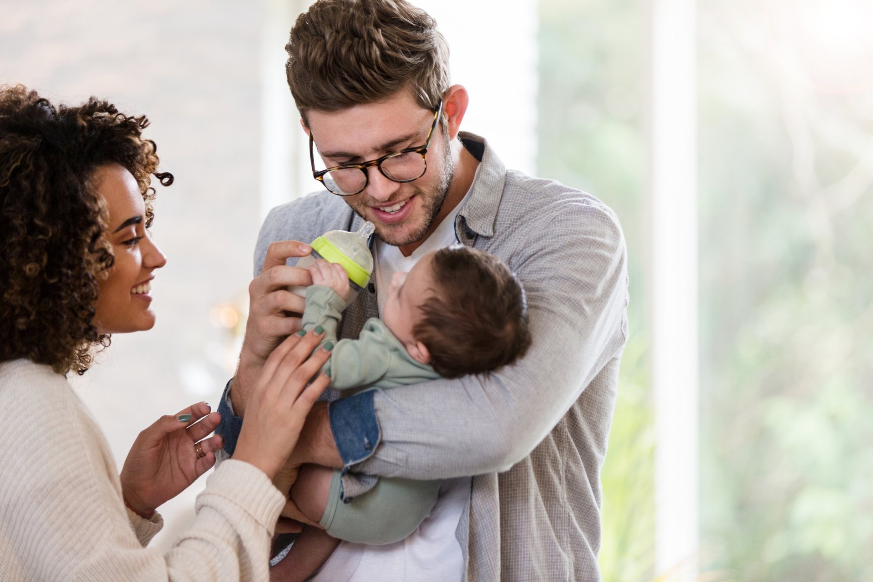 New parents giving baby a bottle